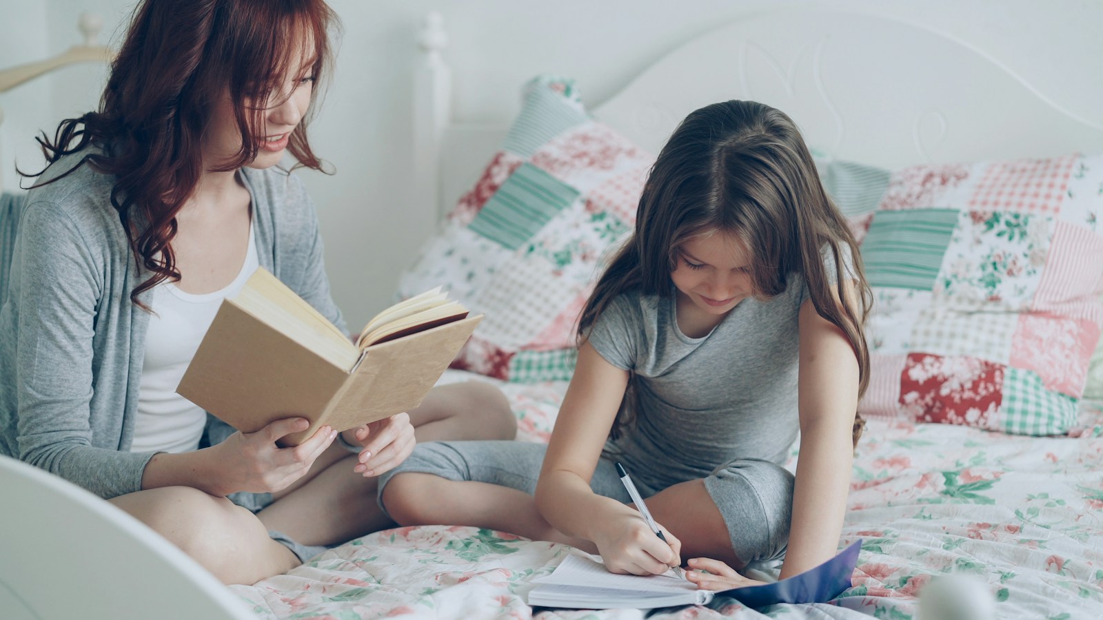 A mother and daughter working through a lesson together at home